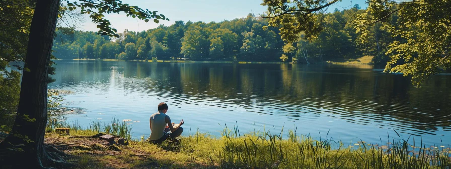 a person calmly practicing deep breathing exercises by a serene lake, surrounded by nature, with a journal and a supportive friend nearby.