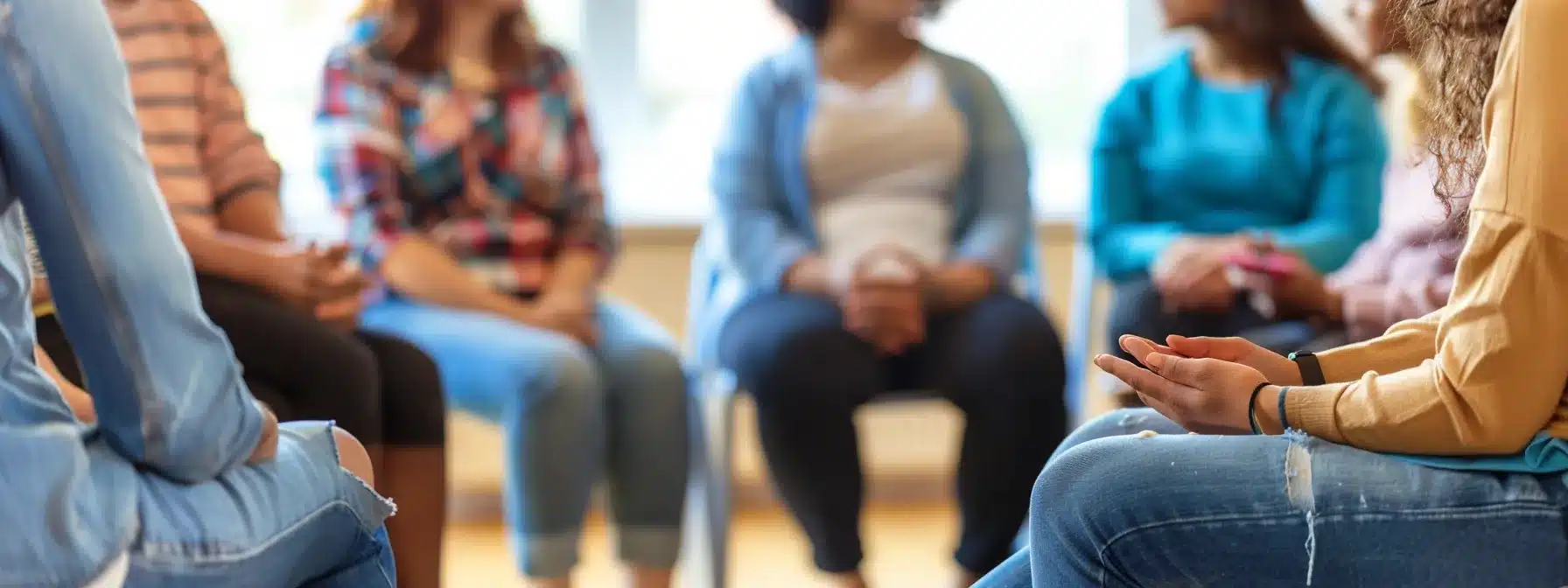 a diverse group of individuals of different ages and backgrounds sitting in a circle during a therapy session, sharing their experiences and supporting each other.