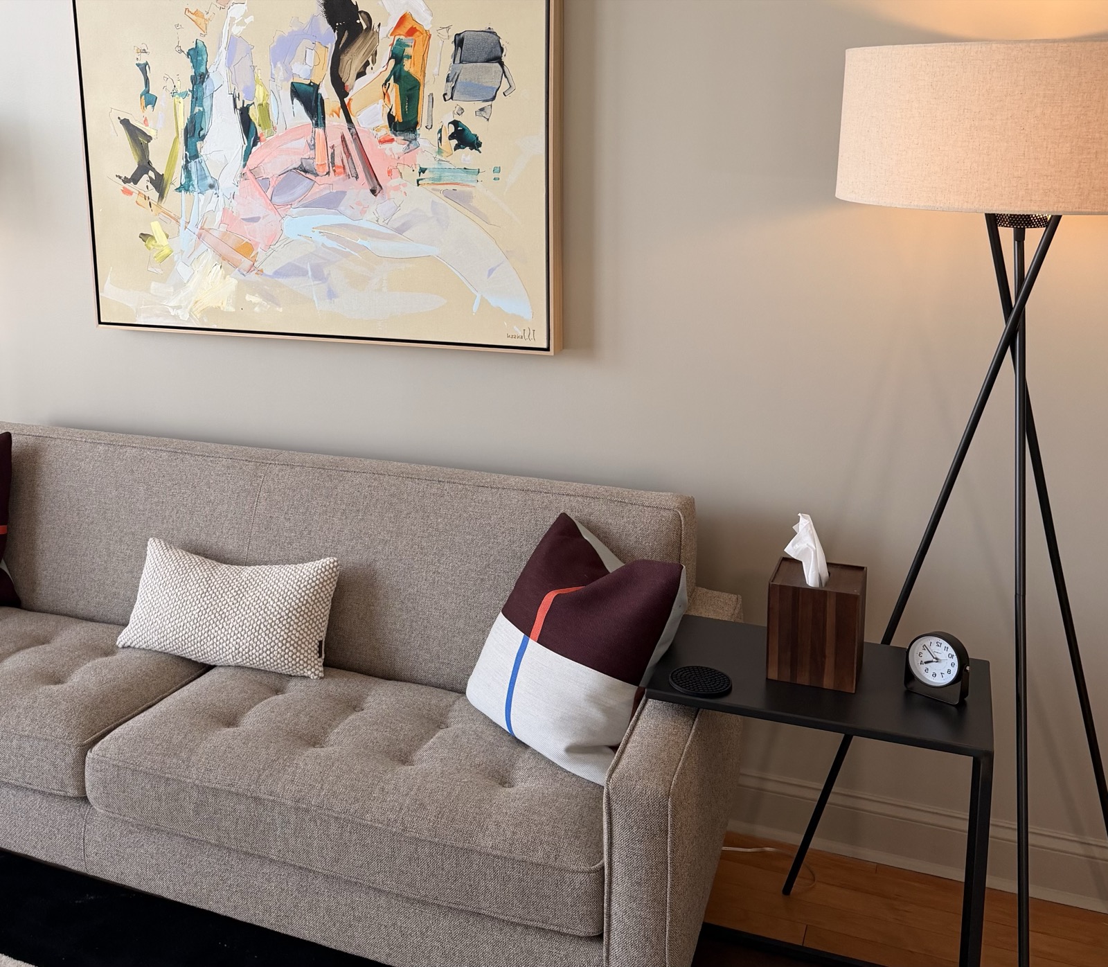 A therapy room at our South End office: a comfortable sofa, warm lamp, and abstract painting